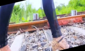 On rail track, a woman walks in heels