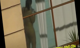 Through the window, we see a girl washing in the shower