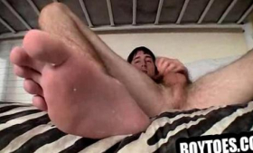 On a bunk bed, two boys tug at their cocks