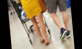Dressed in yellow, a mature Asian woman is shopping